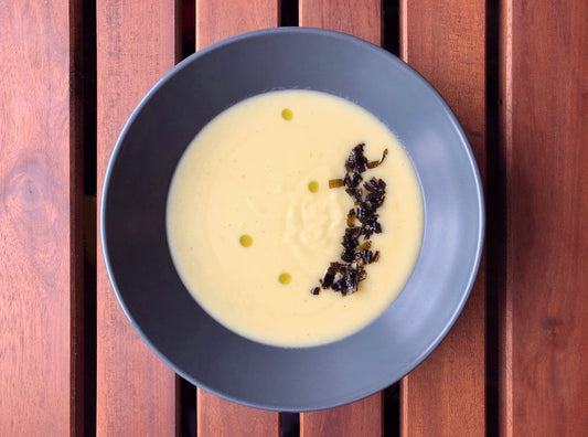bowl of potato leek soup with crispy leek tops and leek oil