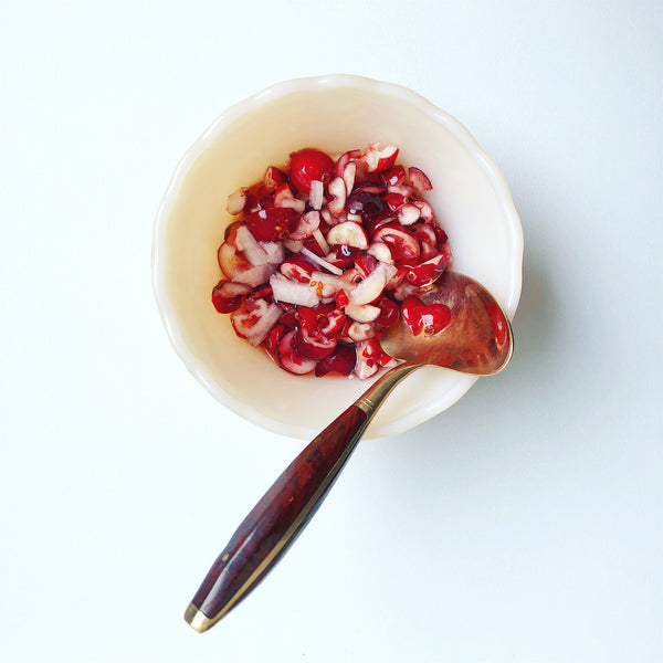 cranberry agrodolce in a bowl, brass spoon with rosewood handle
