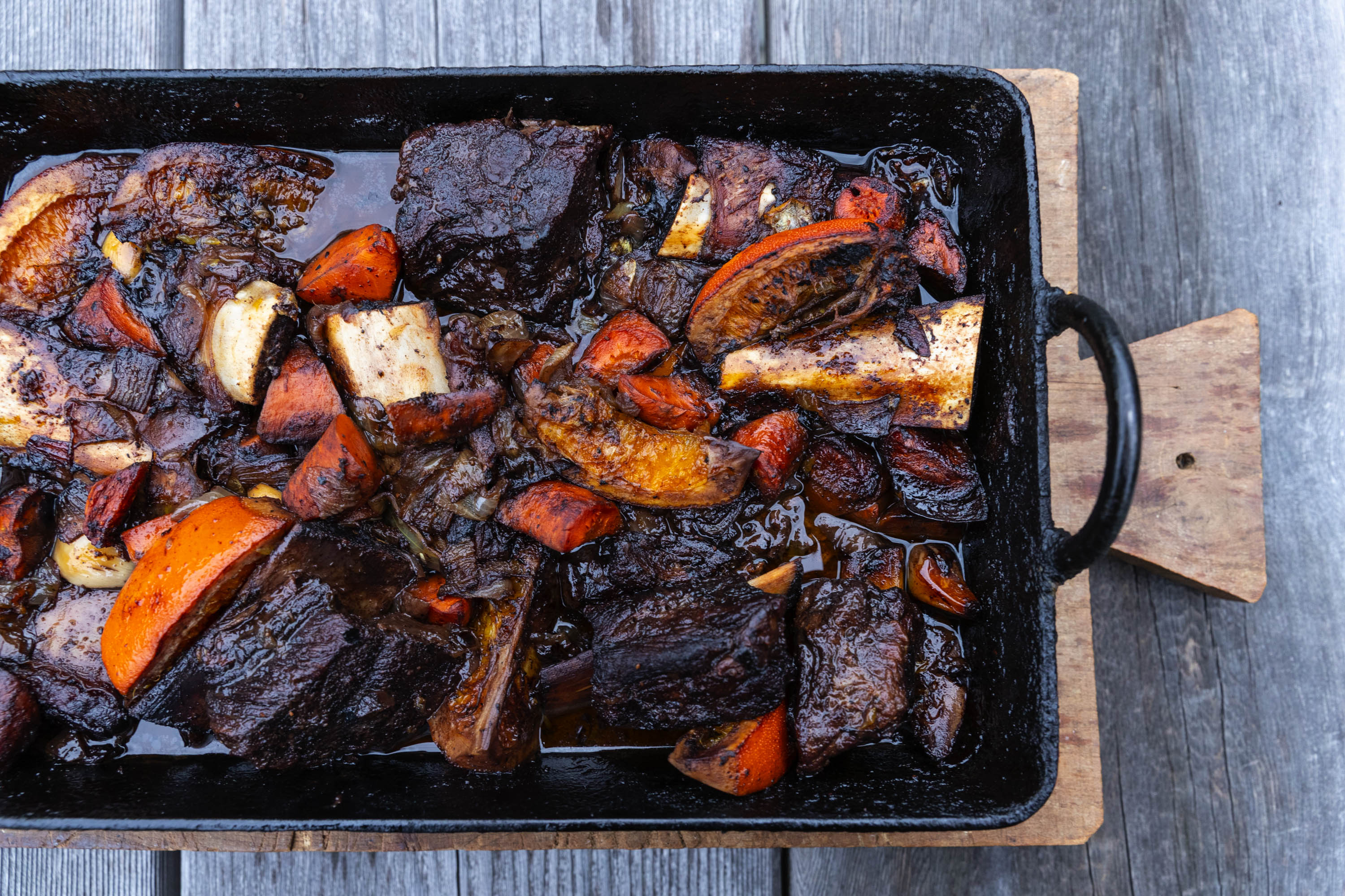 braised short ribs and orange in a pan